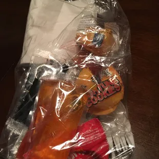 Sauce, cookie, napkins, utensils packaged a plastic bag