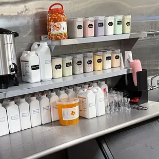 a kitchen counter with a variety of bottles and containers on it