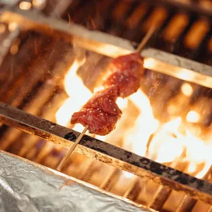 a close up of a shish being cooked on a grill