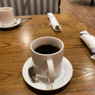 a cup of coffee on a wooden table