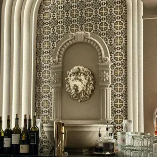 Lion at the bar serves Negronis