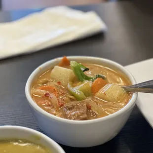 a bowl of soup and a plate of meat