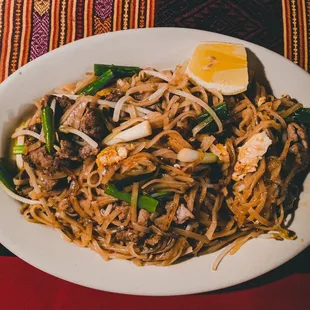 a plate of noodles with meat and vegetables