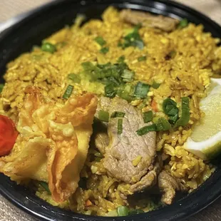 a plate of rice with meat and vegetables