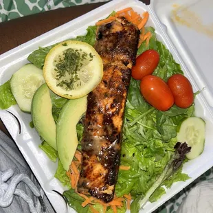 grilled salmon and vegetables in a styrofoam container