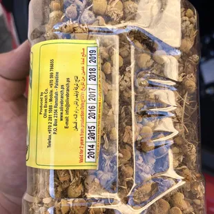 a hand holding a jar of salama halal