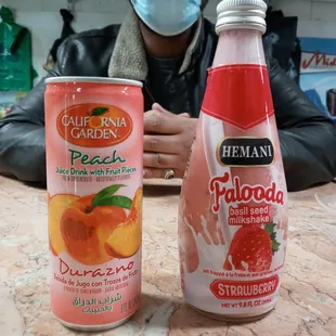 a man sitting at a table next to a can of peachade