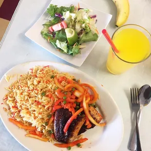 a plate of food and a glass of orange juice