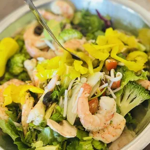 Romaine lettuce, tomatoes, cucumbers, avocado, broccoli, bean sprouts, black olives, pepperoncini and banana peppers, and pumpkin seeds.