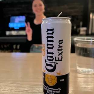 a can of corona beer on a bar