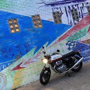 a motorcycle parked in front of a mural