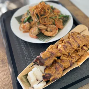 Chicken satay and shrimp fried noodles.