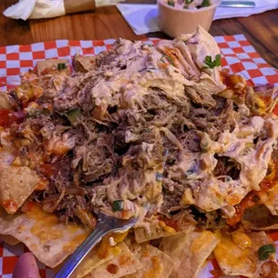 Gigantic pile of shredded pork nachos and beer