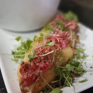 a plate of food with a bowl of soup in the background