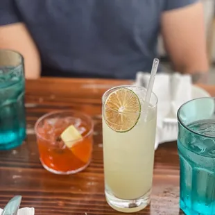 a person sitting at a table with drinks