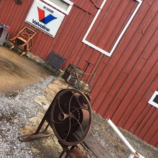 a red barn with a rusty wheel