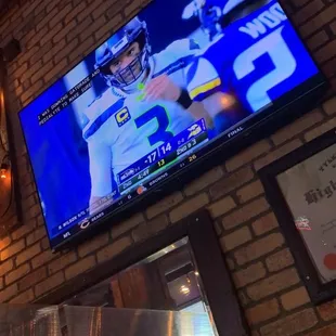 a television on a brick wall