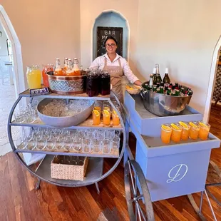 a woman behind a bar cart filled with drinks