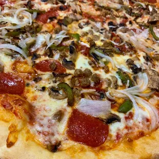 a pizza with pepperoni, mushrooms, onions, and cheese