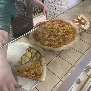 a man cutting a pizza