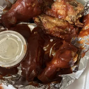 chicken wings and sauce in a styrofoam container