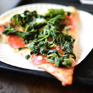 a slice of pizza on a paper plate