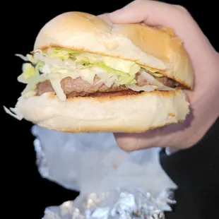 Cheeseburger with lettuce and tomato with ketchup and mayonnaise.