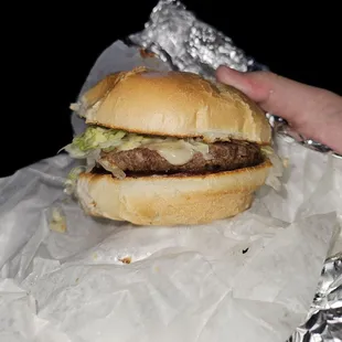 Cheeseburger with lettuce and tomato with ketchup and mayonnaise.
