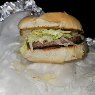 Cheeseburger with lettuce and tomato with ketchup and mayonnaise.