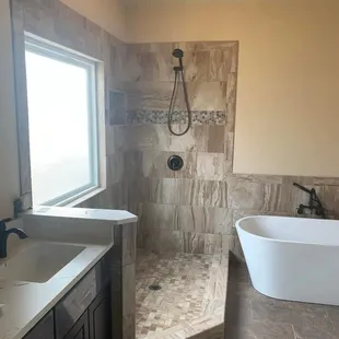 a bathroom with a tub, sink, and shower