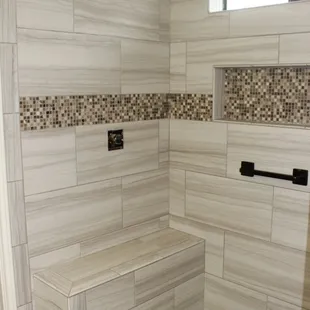 a walk in shower with a bench