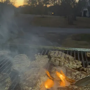 a grill with a lot of food cooking on it