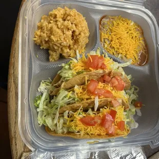 Shredded chicken, crispy tacos with rice and beans