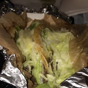 Steak tacos with cheese and lettuce