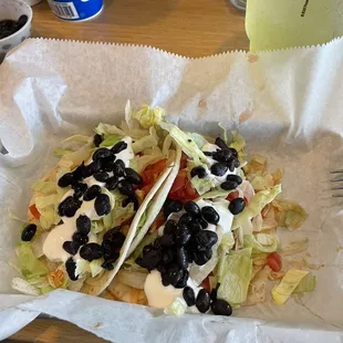 Two chicken soft tacos with black beans and sour cream