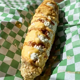 Elote : corn on the cob, covered with Mexican crema, cotija cheese, cheese salsa and hot red salsa