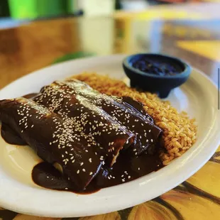 a plate of enchiladas and rice