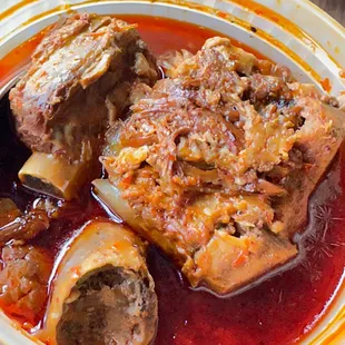 a close up of a bowl of soup with meat and