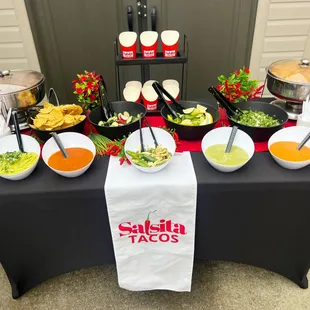 Salsa Bar set up with churro cups in the back. Fresh and always hot rice &amp; beans.