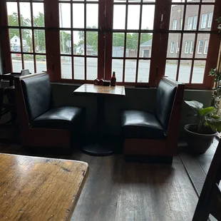 a corner booth with two chairs and a table