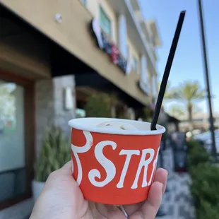 a person holding a cup of ice cream