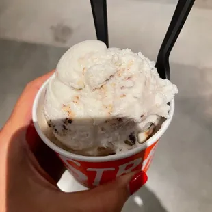 a hand holding a cup of ice cream