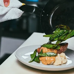 Finishing up a house made KY Proud pork bratwurst with whipped potato, au jus gravy &amp; snow peas.