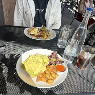 Avocado toast and scrambled eggs and Eggs Benedict Brunch Specialty in the back