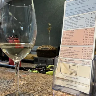 a menu and a glass of wine