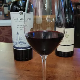 a glass of wine and bottles of wine