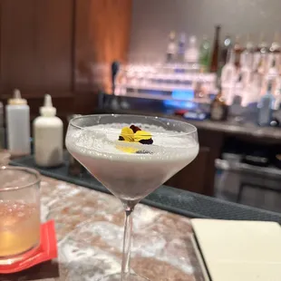 a cocktail in a martini glass on a bar