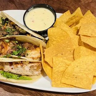 Steak, shrimp and mahi tacos with chips and queso