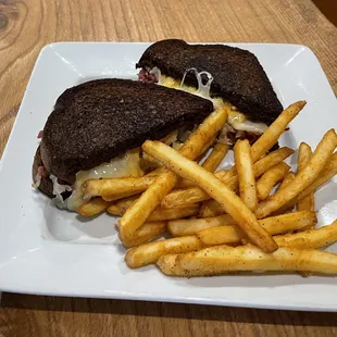 Reuben sandwich with seasoned fries.
