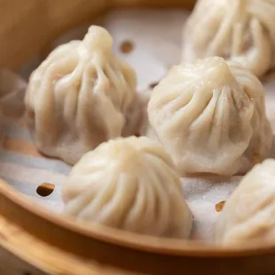a bunch of dumplings in a wooden container